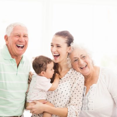 Happy grandparents playing with their grandson at home